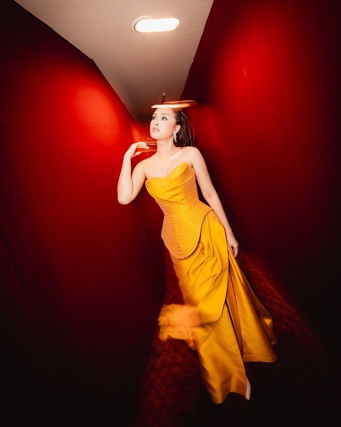 Caitlin Halderman kenakan tube dress kuning ngejreng di gala premiere film barunya.