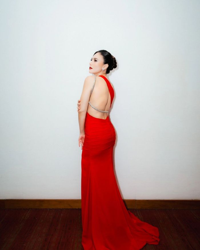 Tampilan Wulan Guritno berbalut dress merah rancangan desainer.