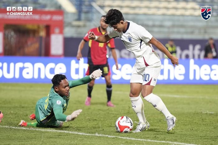 Aksi pemain Thailand, Suphanat Mueanta, berhadapan dengan kiper Timor Leste,  Junildo Pereira, pada matchday pertama Grup A ASEAN Cup 2024 di Stadion Hang Day, Hanoi, Minggu (8/12/2024).