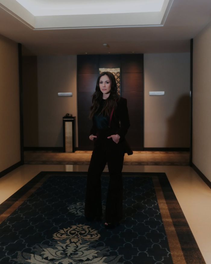 Tampilan fierce Wulan Guritno kenakan setelan jas merah marun.