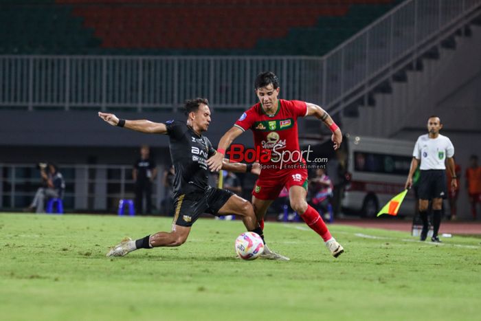 Bruno Moreira (kanan) sedang berebut bola dengan Egy Maulana Vikri (kiri) sedang menguasai bola dan dibayangi Bruno Moreira (belakang) dalam laga pekan ke-24 Liga 1 2024 antara Dewa United FC versus Persebaya Surabaya di Stadion Pakansari, Bogor, Jawa Barat, Jumat (21/2/2025).