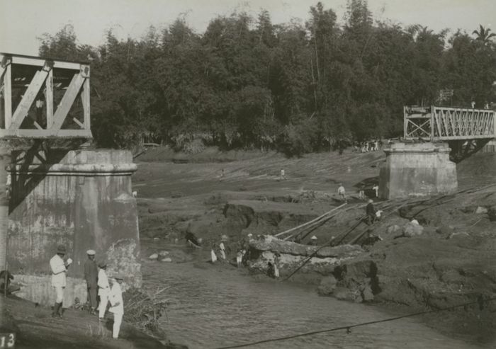 Jembatan kereta api di Kediri yang hancur akibat letusan Gunung Kelut di Jawa Timur pada 1919. Menurut catatan Yudakusuma, rel dan jembatan kereta api yang terdampak banjir lahar segera dibersihkan dan perbaiki oleh orang-orang dari Staatspoorwagen—perusahaan kereta api milik pemerintah kolonial. Foto karya Photografisch Atelier Promemoria.