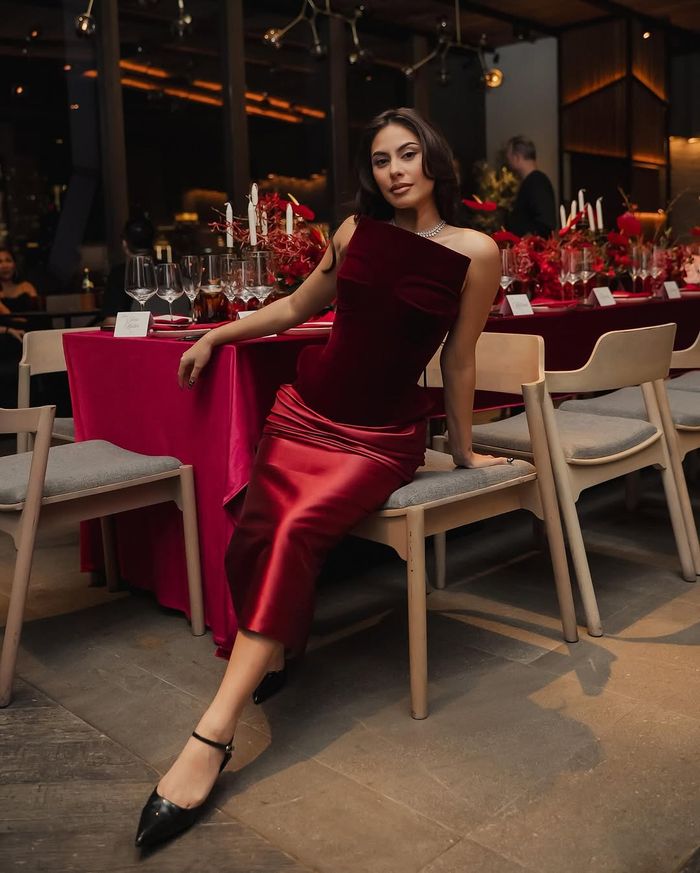 Dress merah dilengkapi dengan pointed heels hitam.