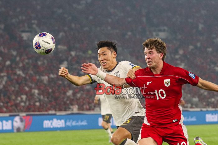 Ole Romeny (kanan) sedang berebut bola dengan Zhu Chenjie (kiri) dalam laga babak penyisihan Grup C Kualifikasi Piala Dunia 2026 zona Asia antara Timnas Indonesia versus Timnas China di Stadion Utama Gelora Bung Karno, Senayan, Jakarta, Kamis (5/6/2025).