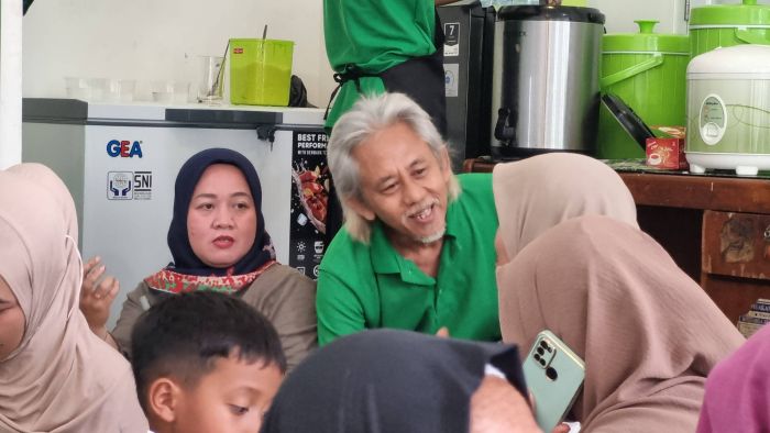 Epy Kusnandar berbincang dengan pelanggan warung makannya di kawasan Pancoran, Jakarta Selatan, Selasa (21/10/2025).