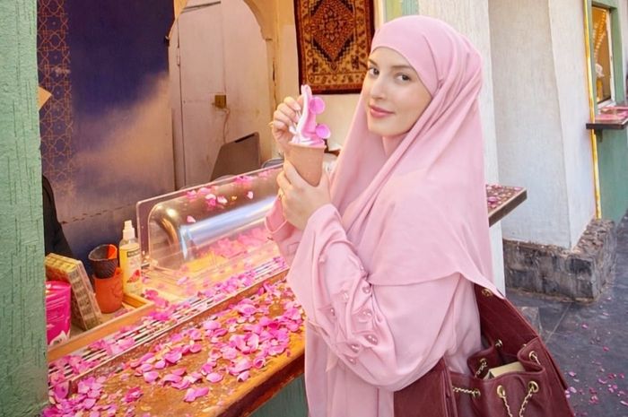 Tasya Farasya berpose saat membeli es krim rose dengan latar bunga-bunga mawar di Madinah