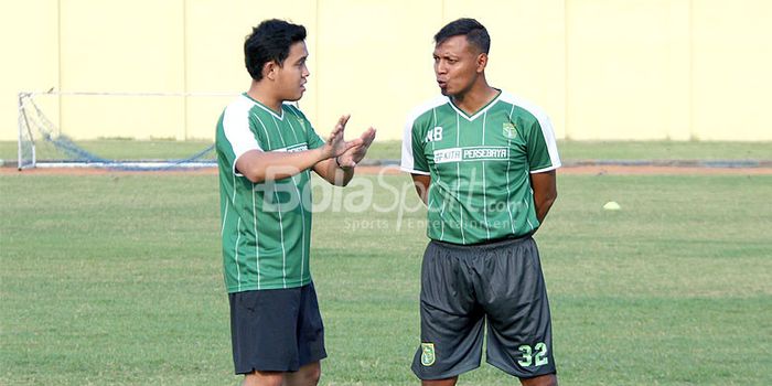 Asisten pelatih Persebaya Bejo Sugiantoro (kanan) berdiskusi dengan salah satu official tim