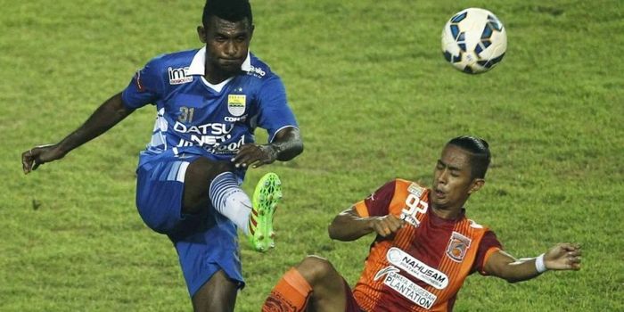 Pemain Persib Bandung Yanto Basna (biru) berebut bola dengan pemain PBFC Fandhy Achmad (orange) pada