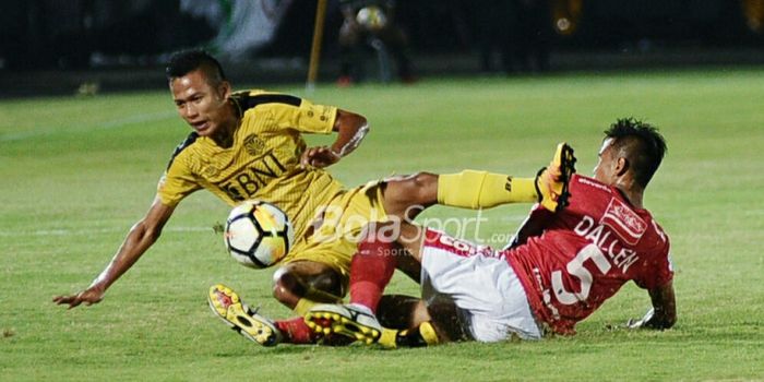 Bek kanan Bali United, Dallen Doke (5/merah), berduel dengan dengan gelandang BFC, Wahyu Subo Seto (