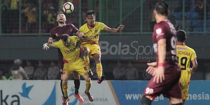 Gelandang bertahan PSM Makassar Marc Klok berebut bola dengan dua pemain Bhayangkara FC di Stadion P