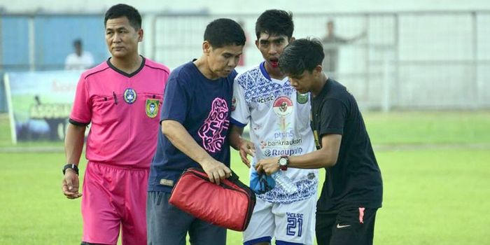 Gelandang PSPS Riau, Firman Septian, dibawa keluar lapangan dengan mulut berdarah setelah dilanggar 