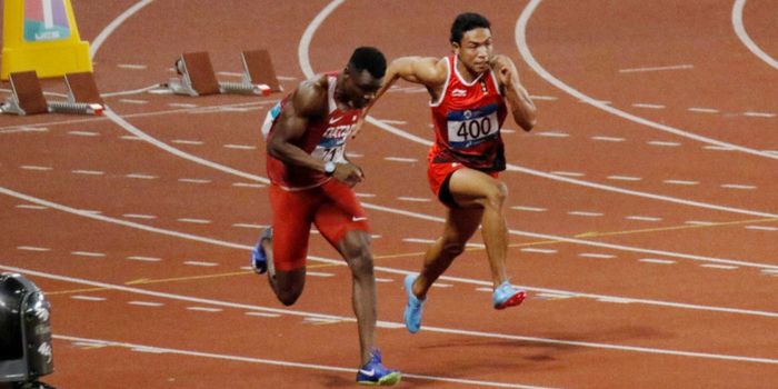 Sprinter asal Indonesia, Lalu Muhammad Zohri (kanan), berduel dengan Tosin Ogunode (Qatar) pada fina