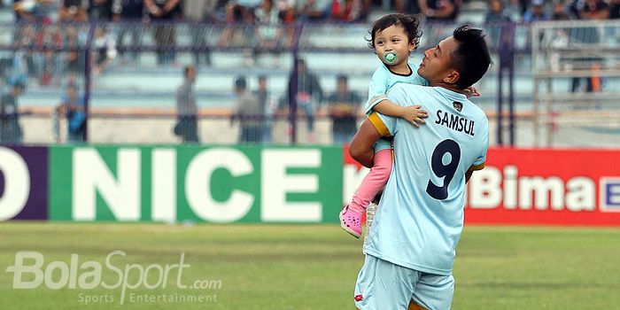   Penyerang Persela Lamongan, Samsul Arif, menggendong putrinya usai laga melawan PS TNI dalam laga 