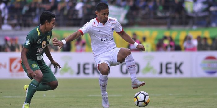 Aksi gelandang Persija Jakarta, Renan Silva, coba dihentikan oleh pemain Persebaya, Misbakus Solikin