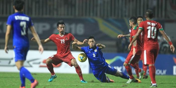   Gelandang Indonesia, Bayu Pradana (19), berduel dengan penyerang Thailand, Sirach Chatthong (9), p