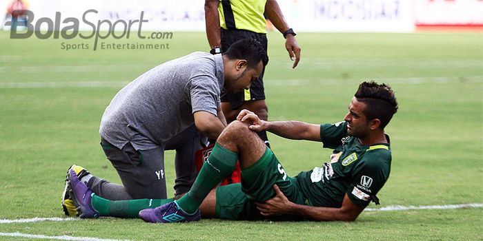 Otavio Dutra menerima perawatan dari tim medis Persebaya saat mengalami cedera.