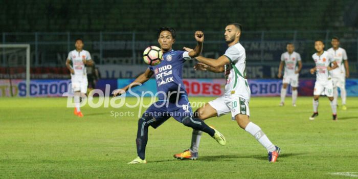 Pemain Arema FC Johan Alfarizie (tengah) berusaha mempertahankan bola dari hadangan gelandang PS TNI