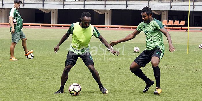 Dua pemain Persebaya, Ricky Kayame (kiri) berusaha melewati Fandli Imbiri pada sesi latihan gim di S