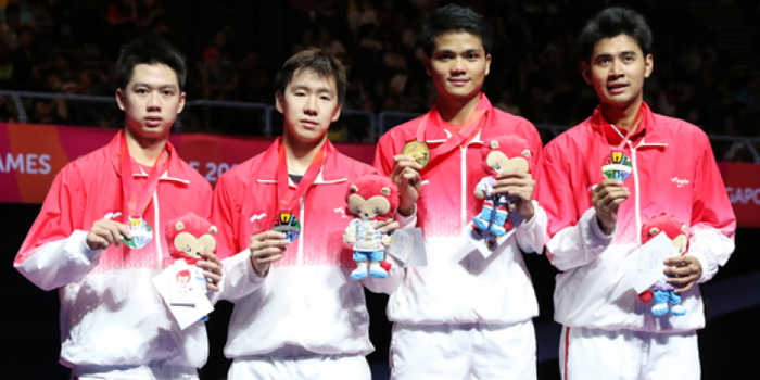 Pasangan ganda putra Indonesia, Angga Pratama/Ricky Karanda Suwardi (kanan) dan Marcus Fernaldi Gideon/Kevin Sanjaya Sukamuljo, berpose dengan medali SEA Games Singapore 2015 mereka di atas podium.