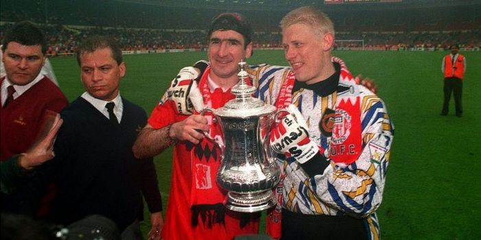  Peter Schmeichel (kanan) berpose bersama Eric Cantona dengan memegang trofi Piala FA yang dimenangi