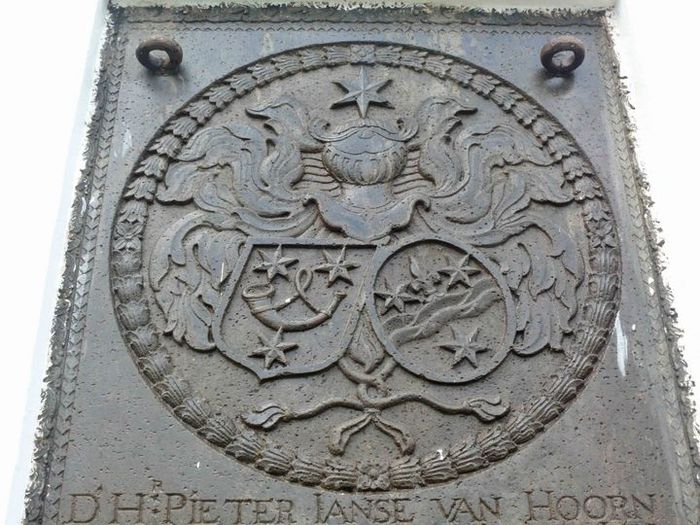 Lambang heraldik keluarga Pieter Janse van Hoorn yang terukir megah di nisannya.