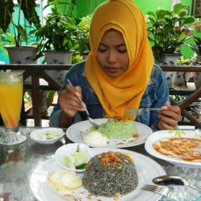 Nasi goreng hitam dengan pewarna hitam dari tinta cumi-cumi yang mempunyai cita rasa gurih dan nikma