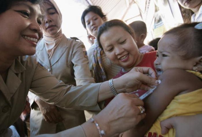 Pekerja kesehatan memvaksinasi seorang anak Indonesia pada akhir Februari 2007, di Jakarta.
