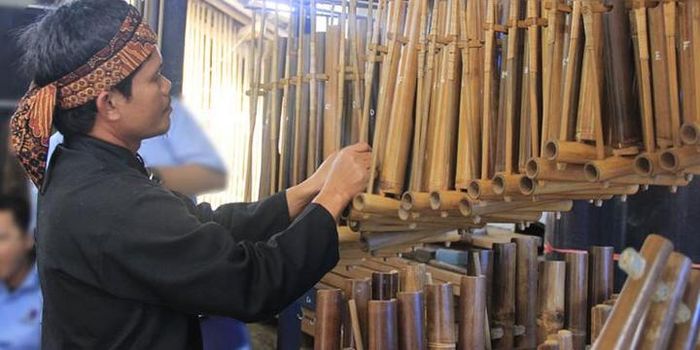Pendi sedang memainkan angklung di Sanggar Angklung miliknya.