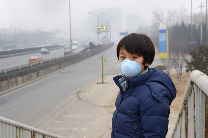 Seorang anak laki-laki menggunakan masker untuk mengurangi efek polusi udara di Beijing, Tiongkok.
