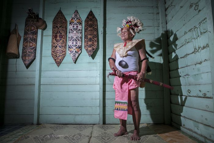 Kayang Ule (67) terlihat gagah memakai pakaian adat suku Dayak saat berpose untuk difoto di kediamannya.