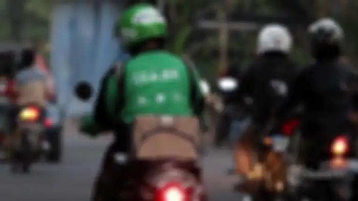Ilustrasi driver Gojek sedang mengatarkan barang