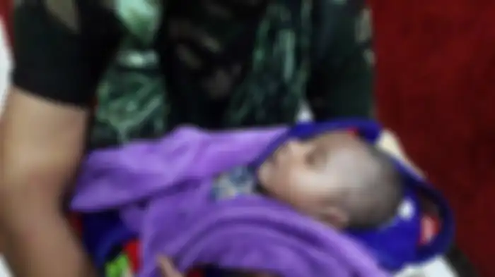 Bayi berusia 5 bulan yang berhasil diselamatkan anggota TNI dari Yonif RK 751/VJS saat terjadi banjir bandang di Kota Sentani, Minggu (16/3/2019). Bayi tersebut sebelumnya enma jam terjebak di kolong rumah. 