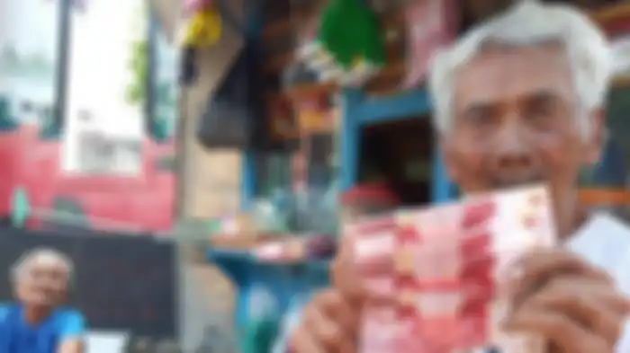 Mbah Suroso (92) bersama istrinya Parjiem (83) menunjukkan uang palsu dari pembeli yang tidak dikenalnya di warungnya di Jalan Ir Juanda, Kelurahan Pucangsawit, Kecamatan Jebres, Solo, Selasa (14/5/2019). 