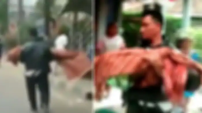 Seorang ayah menggendong jenazah anaknya di Tangerang.