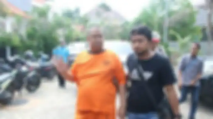 M Adam saat digiring oleh salah seorang petugas.