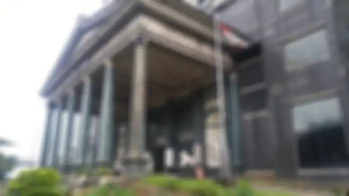 Tampak depan Menara Saidah dengan pilar-pilar hijau besar yang sudah tak terawat