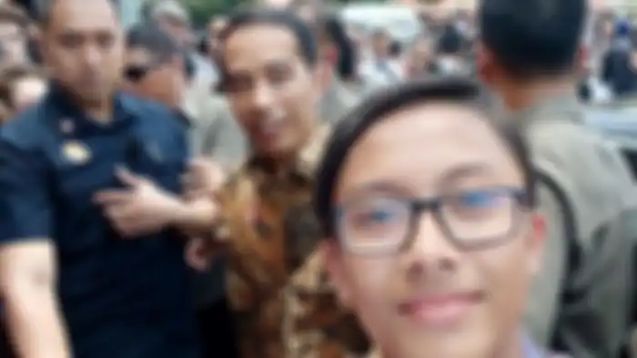 Krisna, seorang bocah SMP asal Jogjakarta, memberanikan diri untuk meminta selfie bersama Presiden RI Joko Widodo atau Jokowi, di acara Hari Batik Nasional 2019 di Pura Mengkunegaran, Solo, Rabu (2/10/2019). 