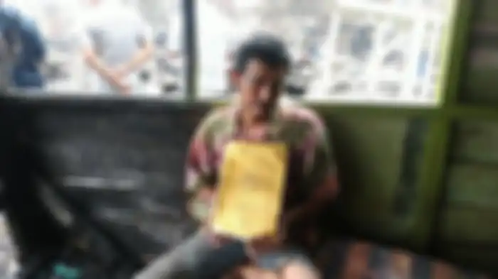 Yusuf (49) saat menunjukkan Alquran miliknya yang tak hangus terbakar saat kebakaran di jalan.