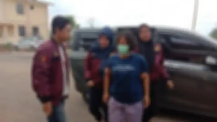Tersangka ibu tiri bakar tangan anak di atas kompor menyala saat di Mapolres Pesawaran, Kamis (12/12/2019). 