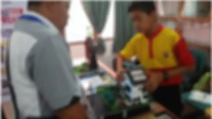Salah seorang kepala sekolah ketika mendengarkan penjelasan siswa tentang konsep bangunan ramah lingkungan. 
