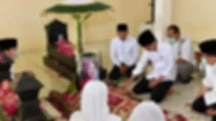 Presiden Joko Widodo (Jokowi) duduk disamping pusara ibundanya Sujiatmi Notomihardjo di pemakaman Keluarga Mundu, Selokaton, Gondangrejo, Karanganyar, Jawa Tengah, Kamis (26/3/2020) 