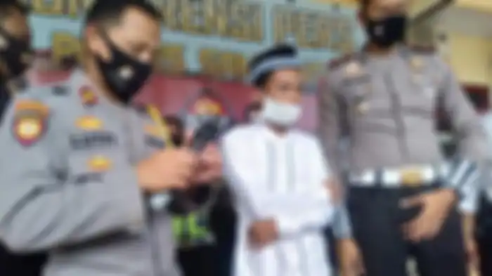 Abdullah (tengah) saat berada di Mapolres Sampang, Senin (13/7)..