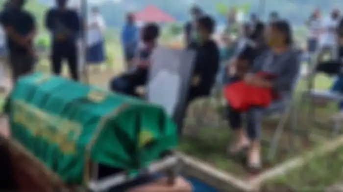 Bawuk putri bungsu Sapardi Djoko Damono memegan foto besar almarhum ayahnya di depan jenazah sang ayah di TPU Giritama, Giti Tonjong, Bogor Jawa Barat, Minggi (19/7/2020).