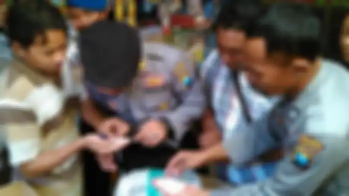Periksa Beras- Sejumlah anggota Polres Bojonegoro memeriksa beras di pasar Bojonegoro dalam operasi pasar mengantisipasi beredarnya beras plastik, Rabu (30/5). 