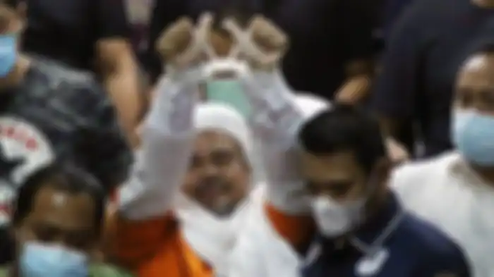 Pemimpin Front Pembela Islam (FPI) Muhammad Rizieq Shihab mengenakan baju tahanan seusai menjalani pemeriksaan di Polda Metro Jaya, Jakarta Pusat, Minggu (13/12/2020) dini hari. 
