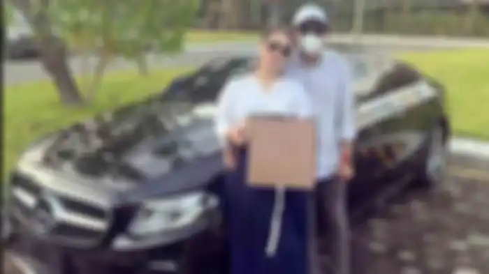 Shyalimar Malik megunggah sebuah foto sedang memamerkan mobil Mercedez Benz baru tanpa nomor polisi, dan uang dolar yang ada didalam sebuah kotak bunga. 8-