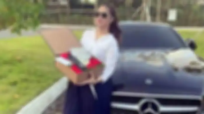 Shyalimar Malik megunggah sebuah foto sedang memamerkan mobil Mercedez Benz baru tanpa nomor polisi, dan uang dolar yang ada didalam sebuah kotak bunga. 