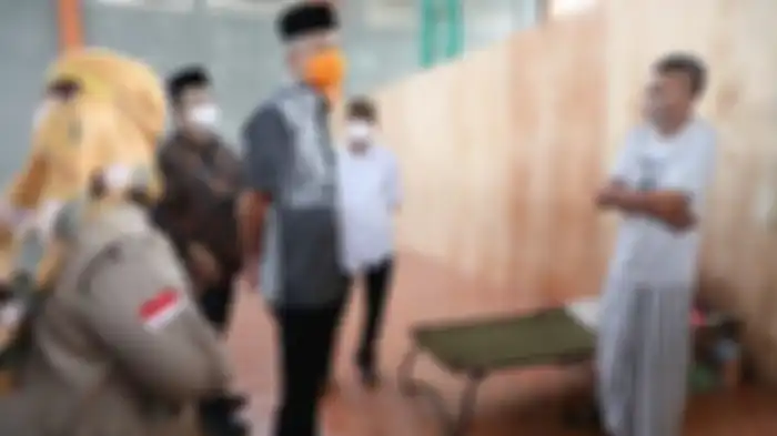 Gubernur Jawa Tengah Ganjar Pranowo saat berdialog dengan Wagiman, pemudik yang dikarantina di GOR Satria Purwokerto, Jumat (7/5/2021). 
