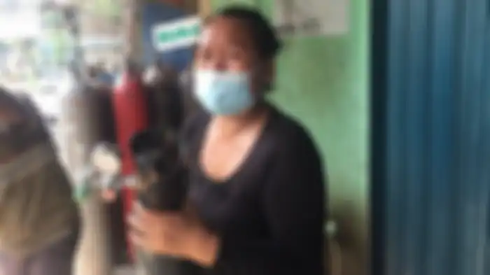 Nurdini menangis saat mengantre isi ulang tabung oksigen di depot pengisian oksigen CV Rintis Usaha Bersama (RUB) di Jalan Minangkabau, Setiabudi, Jakarta Selatan, Minggu (4/7/2021).