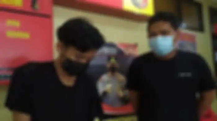 DF (Kiri, masker hitam) seorang pemuda 21 tahun di Palembang, Sumatera Selatan tersangka penyebar video asusila kekasihnya digiring ke Polrestabes Palembang, Rabu (24/11/2021). 